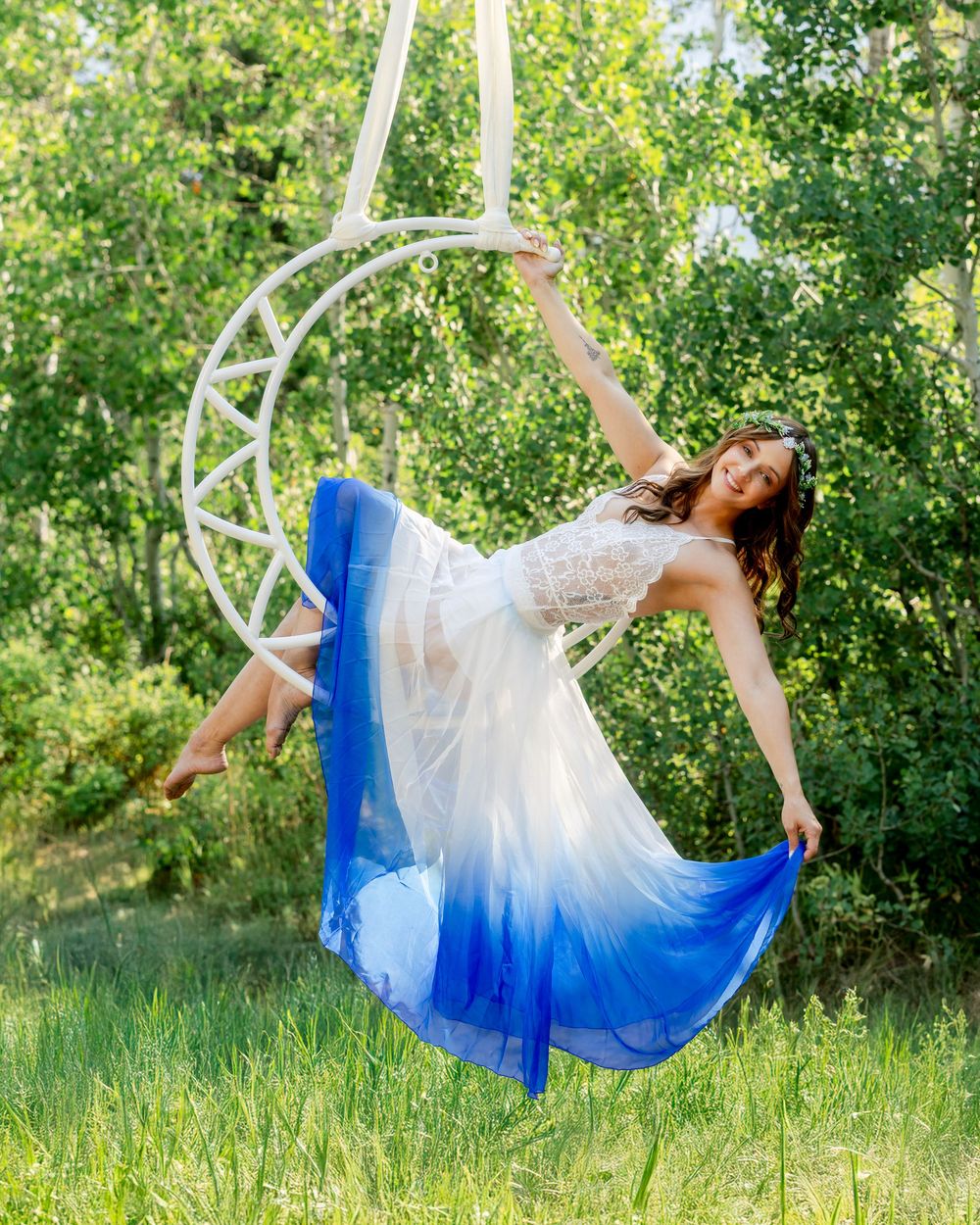 Aerialist performing graceful inversions on hoop — professional aerial hoop photography highlighting power, control, and artistry.