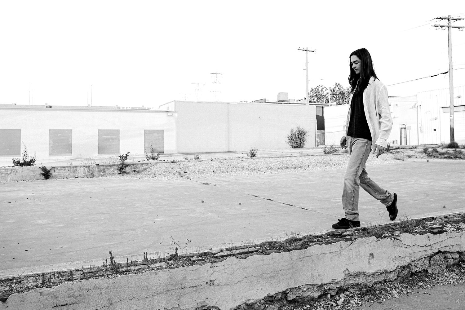 High School Senior boy sitting on brick wall  in urban setting in downtown Springfield MO.