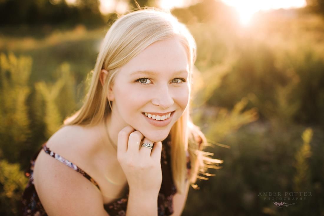 Senior portrait at golden hour in open field – Amber Potter Photography Springfield MO.