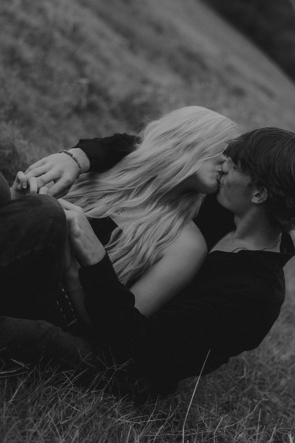 A black and white sequence of images showing a person with long hair lying down in grass.