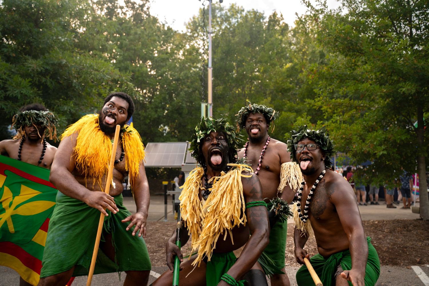 Traditional African dancers perform in colorful yellow costumes during an outdoor cultural festival, ethnic performances