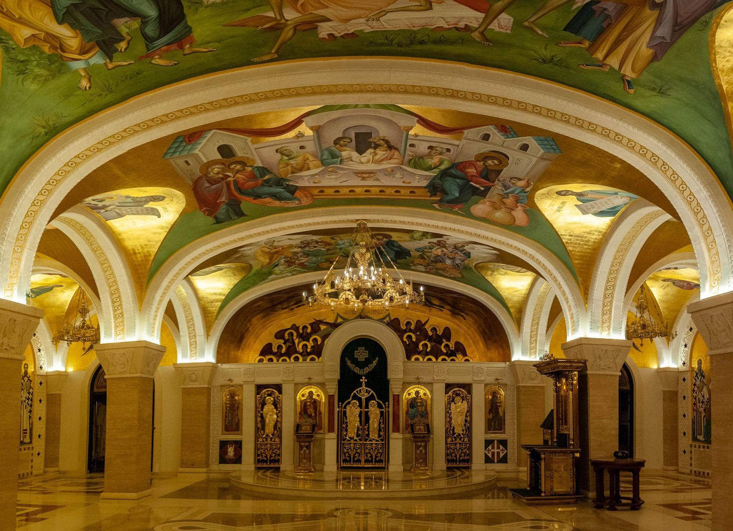 Panoramic view of an ornate underground metro station with vaulted ceilings, chandeliers and classical architecture in Moscow.