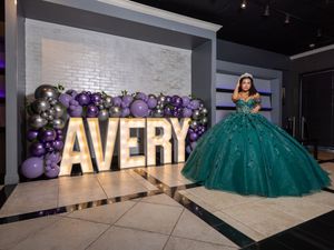 A collage of photos showing a glamorous quinceañera celebration with emerald green gown and large gold AVERY letters.