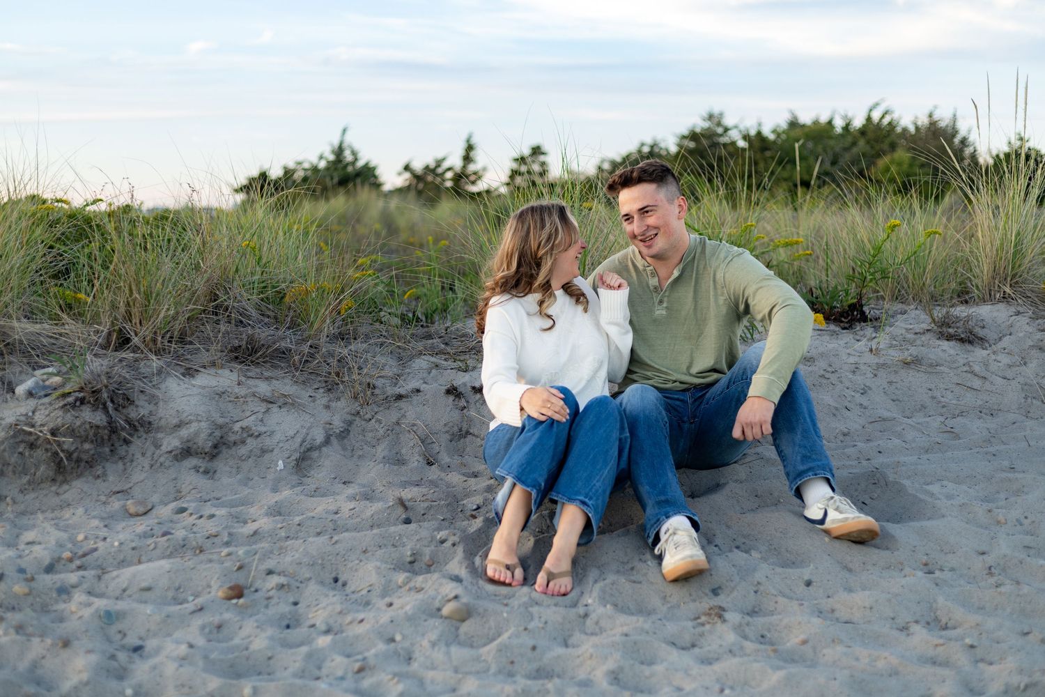 A romantic engagement photo session in a golden marsh field during sunset.