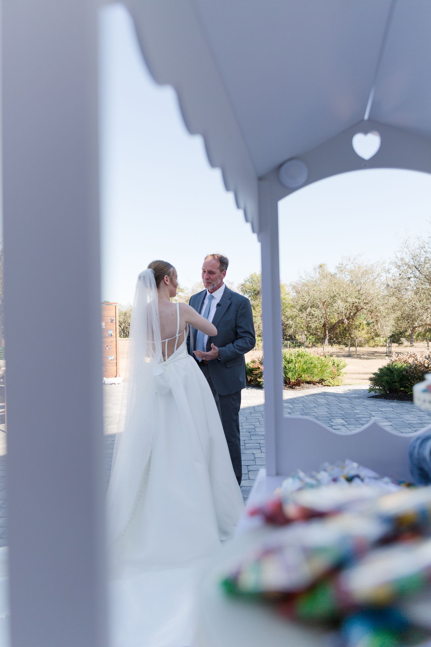 Bride and groom sharing private vows on a sunlit outdoor porch at their wedding.