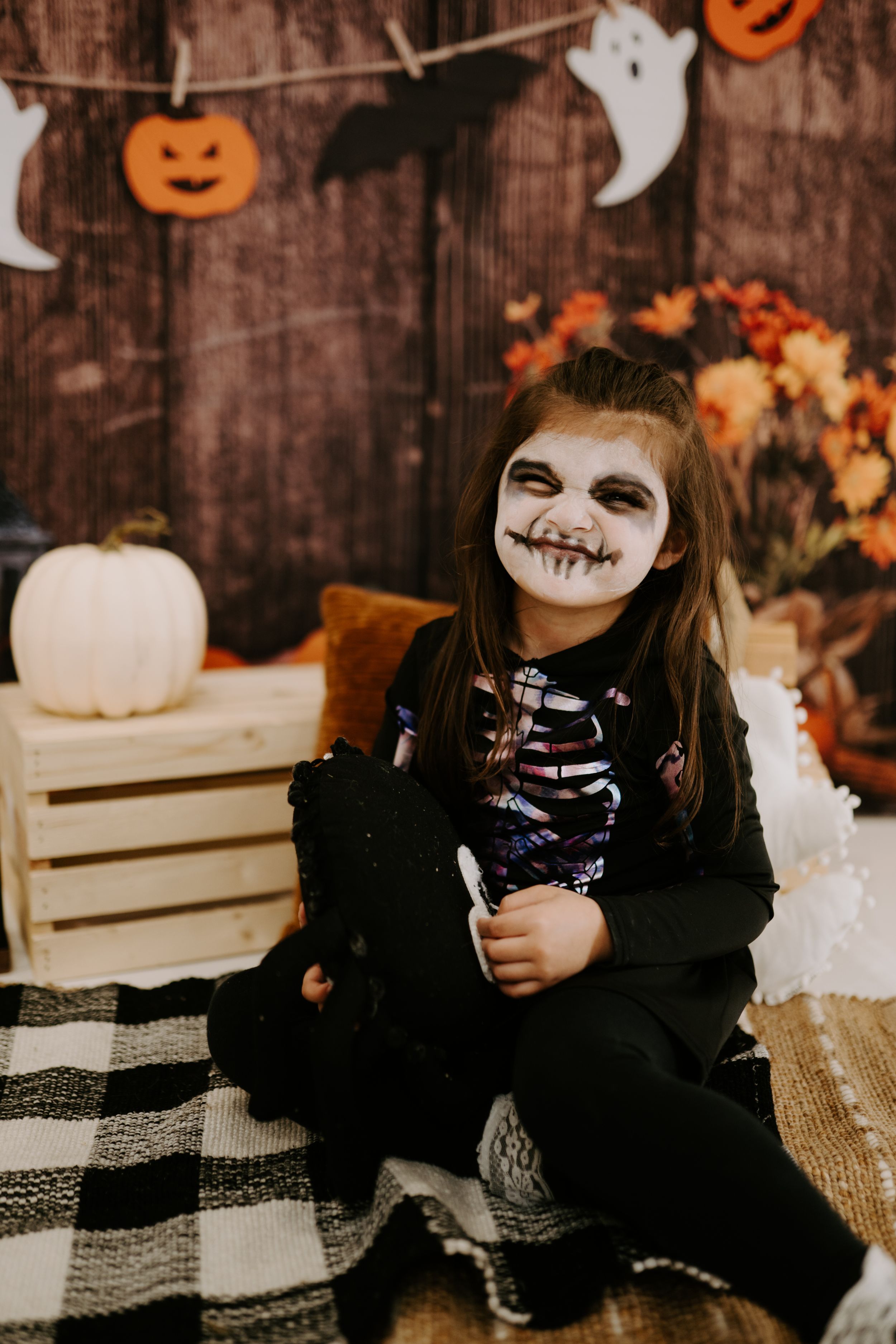 Halloween scene with pumpkins and autumn decor featuring a spooky skeleton costume.