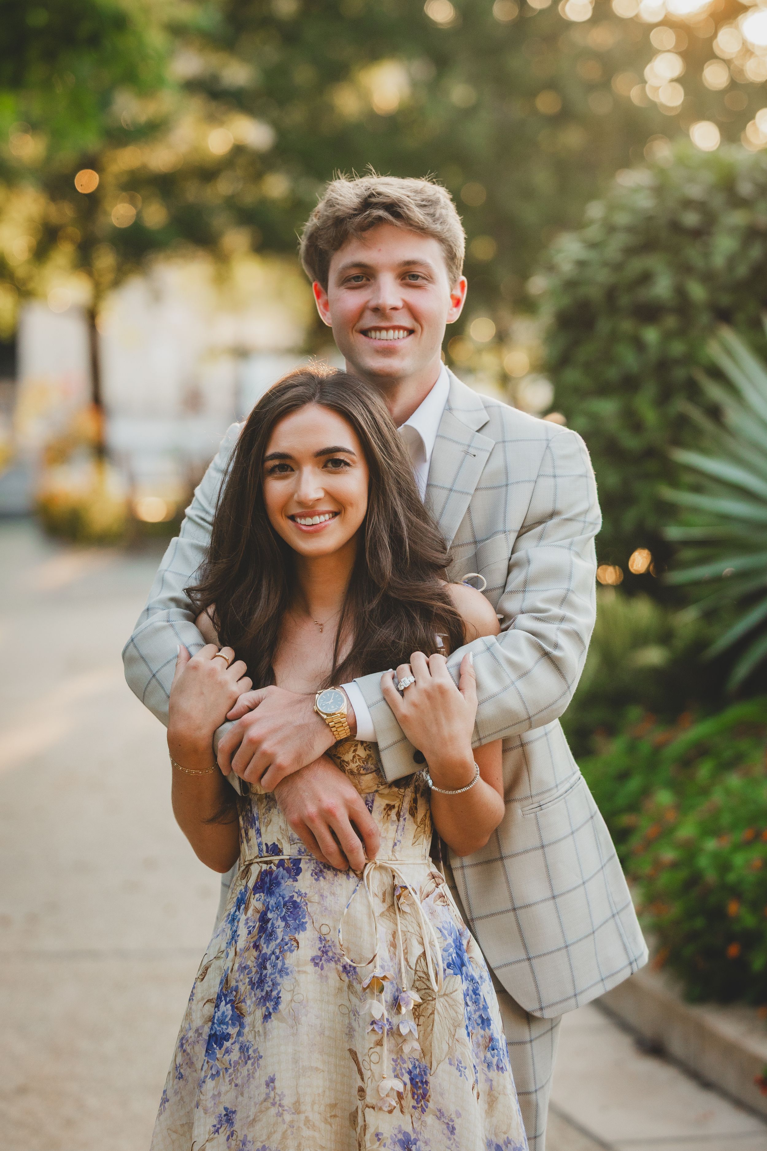 A joyful engagement photo showing a couple embracing in golden sunset light
