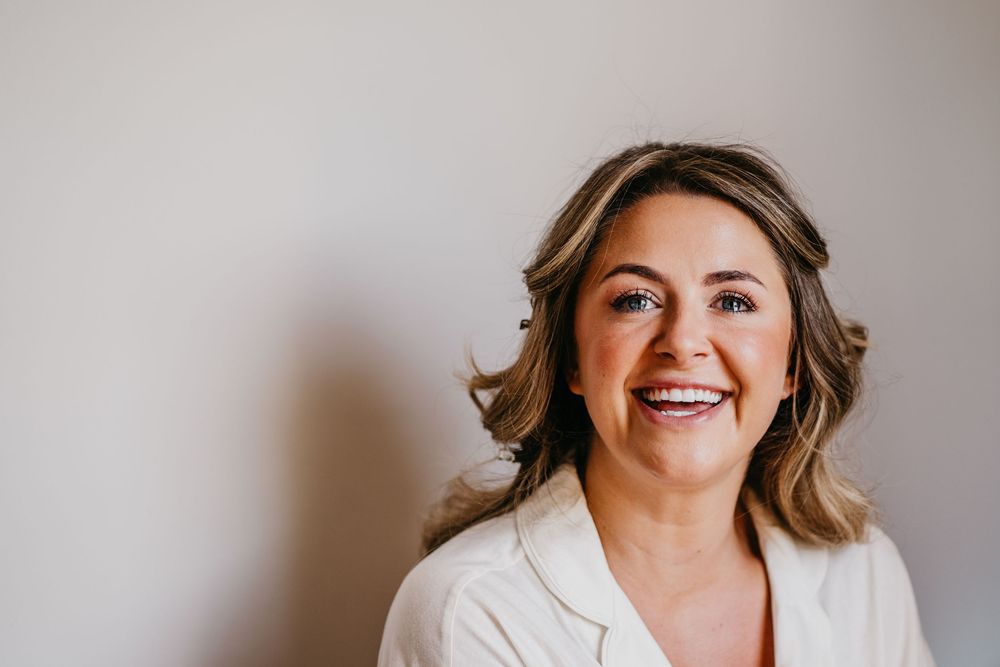 Professional headshot photos showing a woman in a gray blazer smiling against a neutral background.