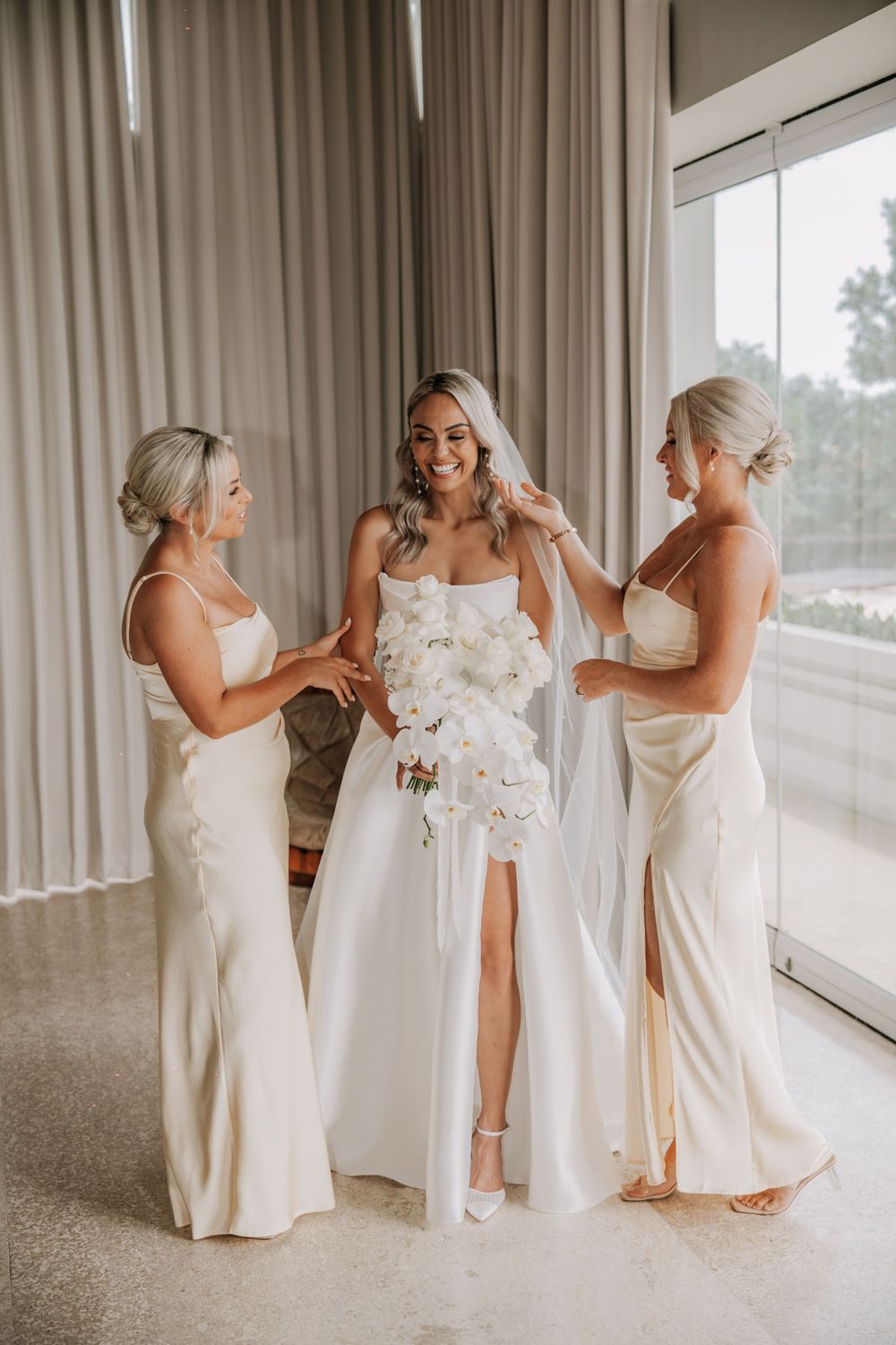 A sequence of wedding party photos shows bridesmaids in white dresses dancing and celebrating together in a bright room.