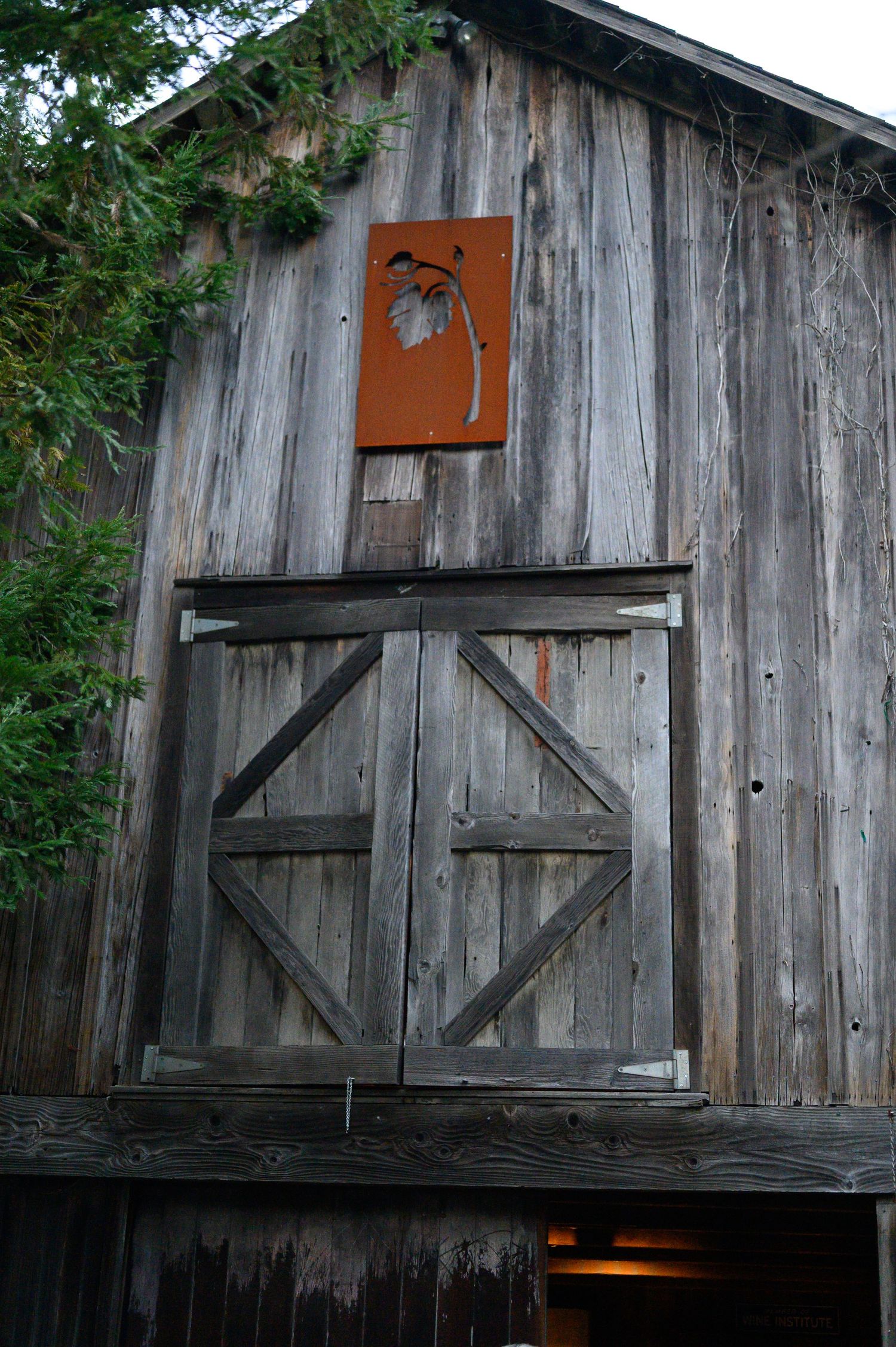 The tasting room, rustic wooden barn at Reid Family Vineyard with their Logo displayed at the top.