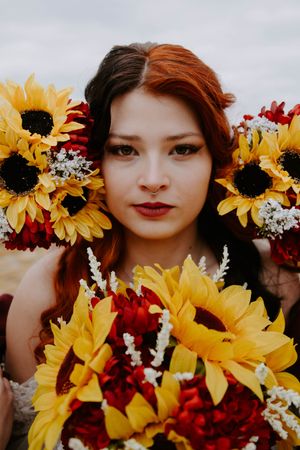 Vibrant sunflowers and red flowers create a dramatic wedding bouquet display.