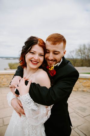 Joyful wedding couple shares laughter and embraces during their outdoor photo session.