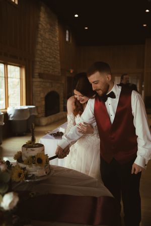 Intimate reception moments captured in warm lighting as couple shares cake cutting ceremony.
