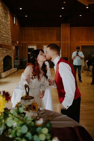 Romantic reception scene with couple sharing tender moments in rustic venue setting.