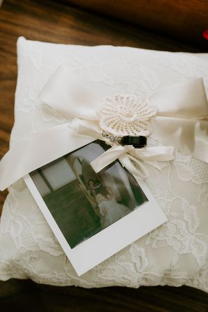 Vintage polaroid photos displayed on delicate lace wedding pillow.