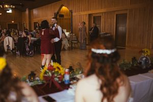 Wedding reception hall decorated with wooden walls and tables set for celebration.
