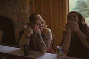 Emotional wedding moment captured in a rustic barn setting with warm lighting.