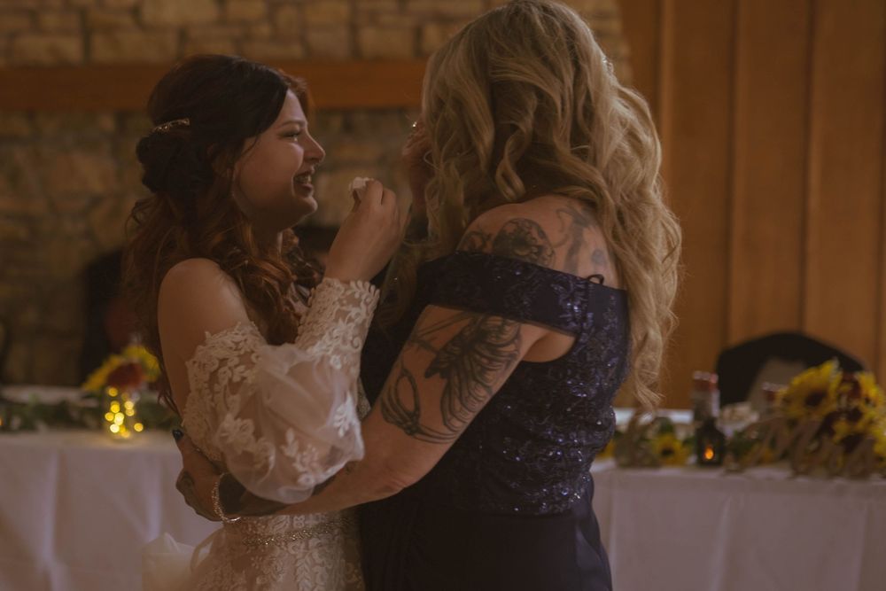 Wedding reception venue features stone walls and elegant table settings with natural lighting.