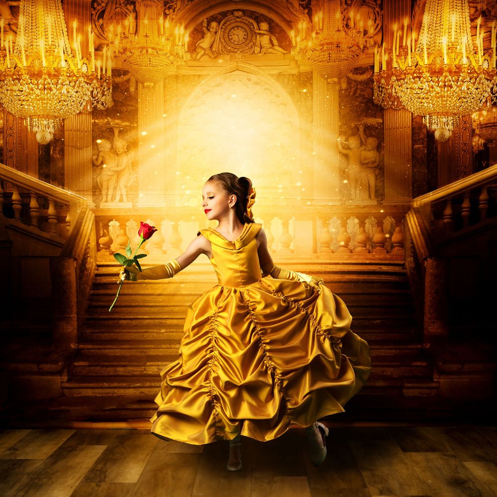 Elegant golden gown flowing across grand ballroom floor with crystal chandeliers overhead.