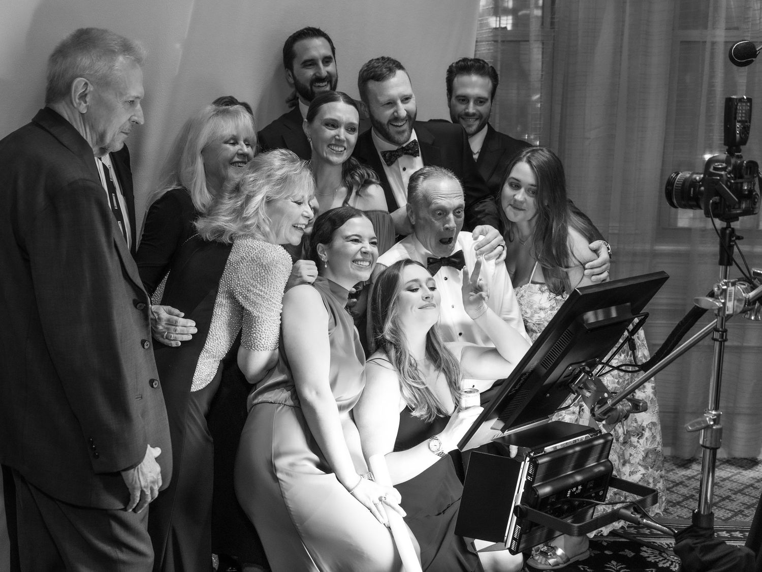 Wedding guests pose for a large group photo in a luxury glam photo booth at Detroit Athletic Club