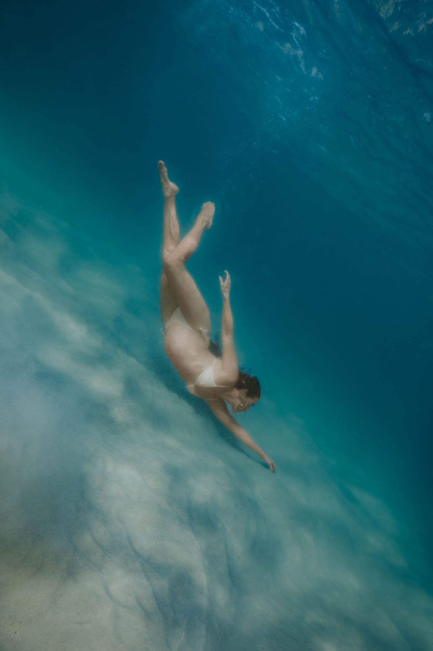 Underwater Maternity Photographer on the Sunshine Coast in a heated pool with toddler Surf and Ocean water maternity shoos