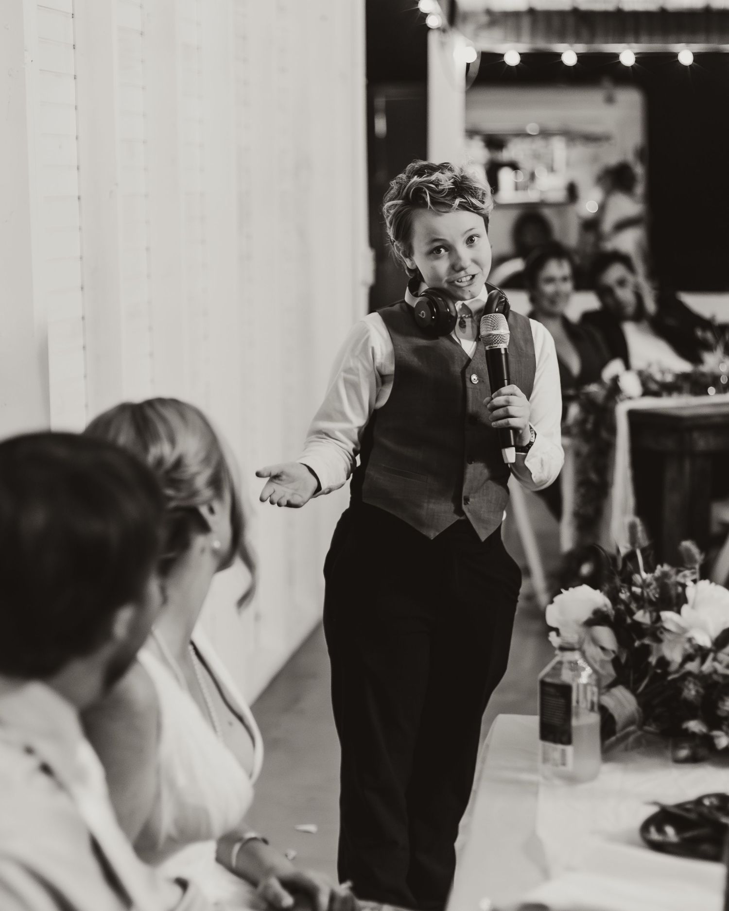 Black and white candid reception photo capturing wedding toasts and celebrations.