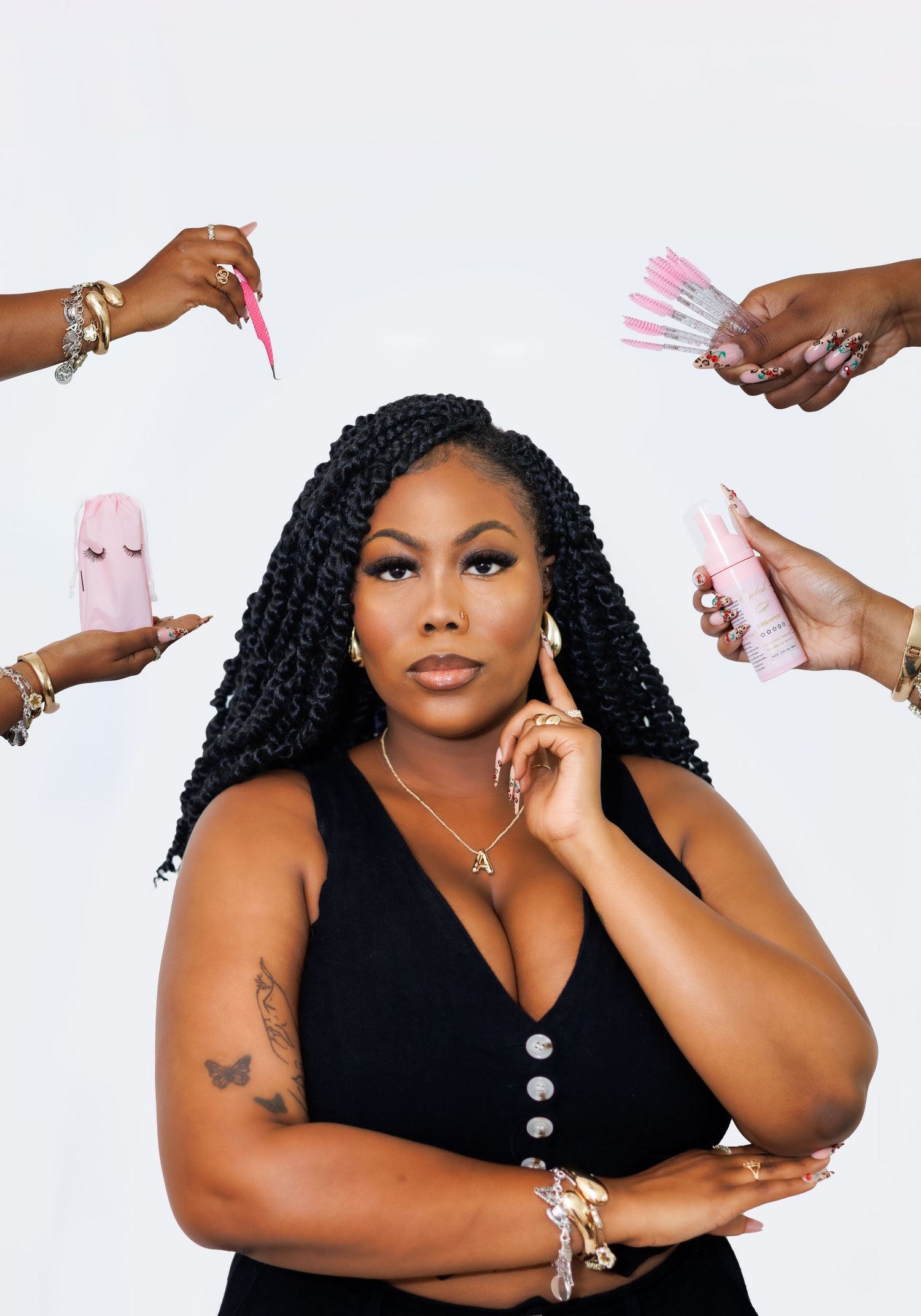 Branding portrait of a Dallas woman wearing a black shirt against white background with hands holding pink beauty tools and products.