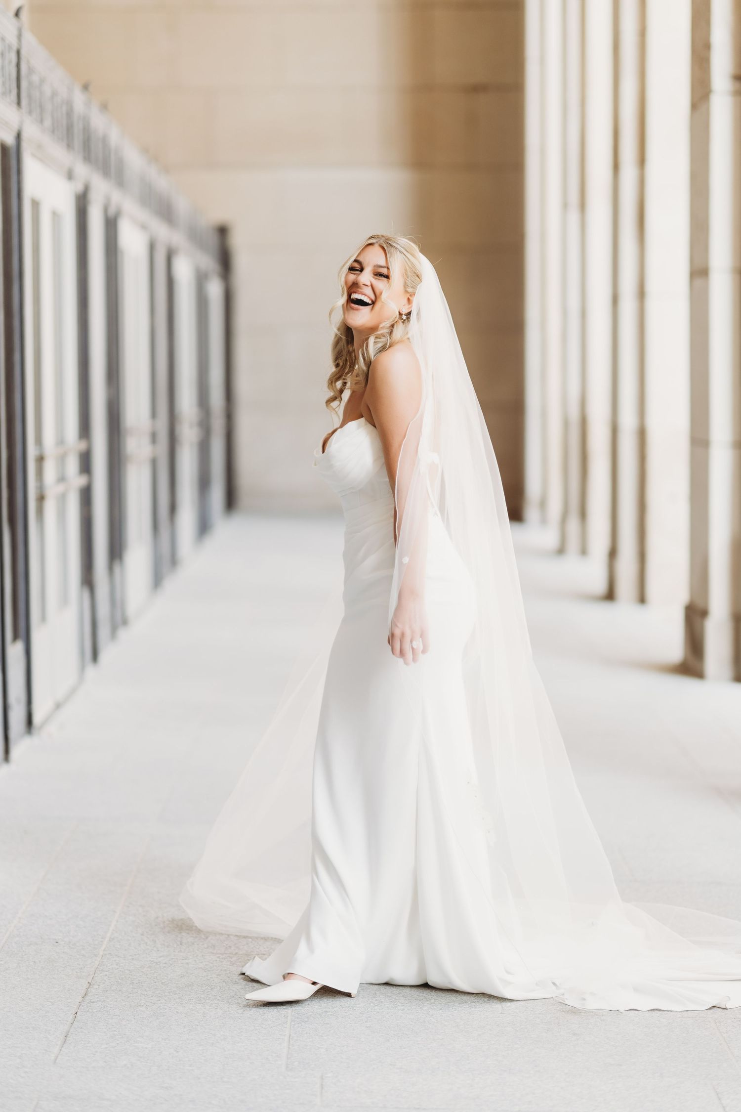 Joyful wedding moments captured in a bright columned gallery. Grand Rapids Michigan