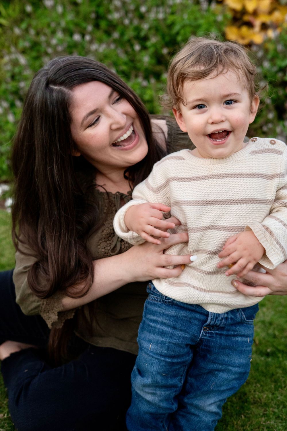 A playful sequence of candid moments between parent and child sitting on grass outdoors on a sunny day.