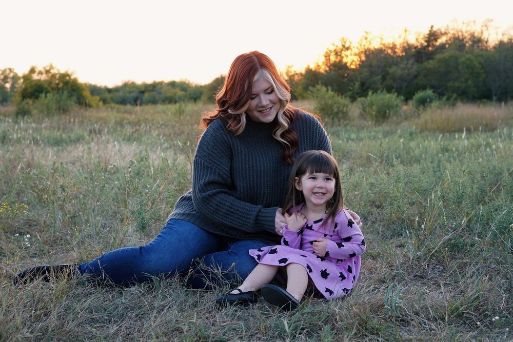 A series of candid family photos taken outdoors at sunset showing people sitting and interacting in a grassy meadow.