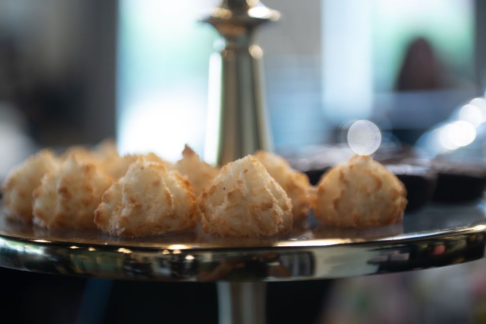 Light and flaky pastries displayed on a dark serving platter with soft bokeh background.