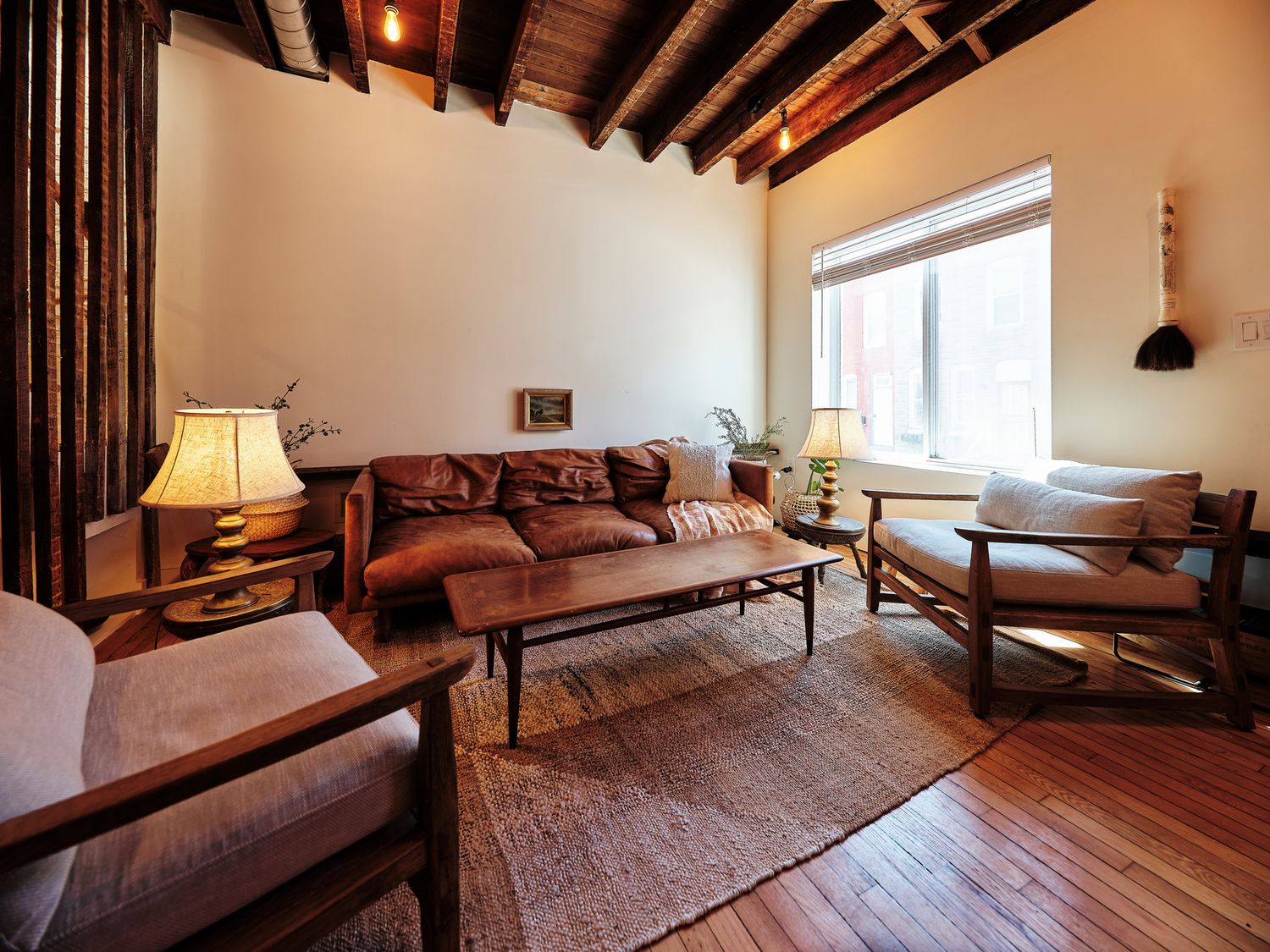 Stylish living room interior with exposed joists and leather furniture in Baltimore City.