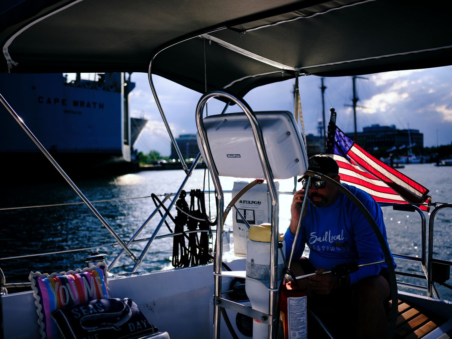 Senate Candidate, Bobby LaPin steering boat with American flag flying on the Patapsco River. Baltimore lifestyle photography.