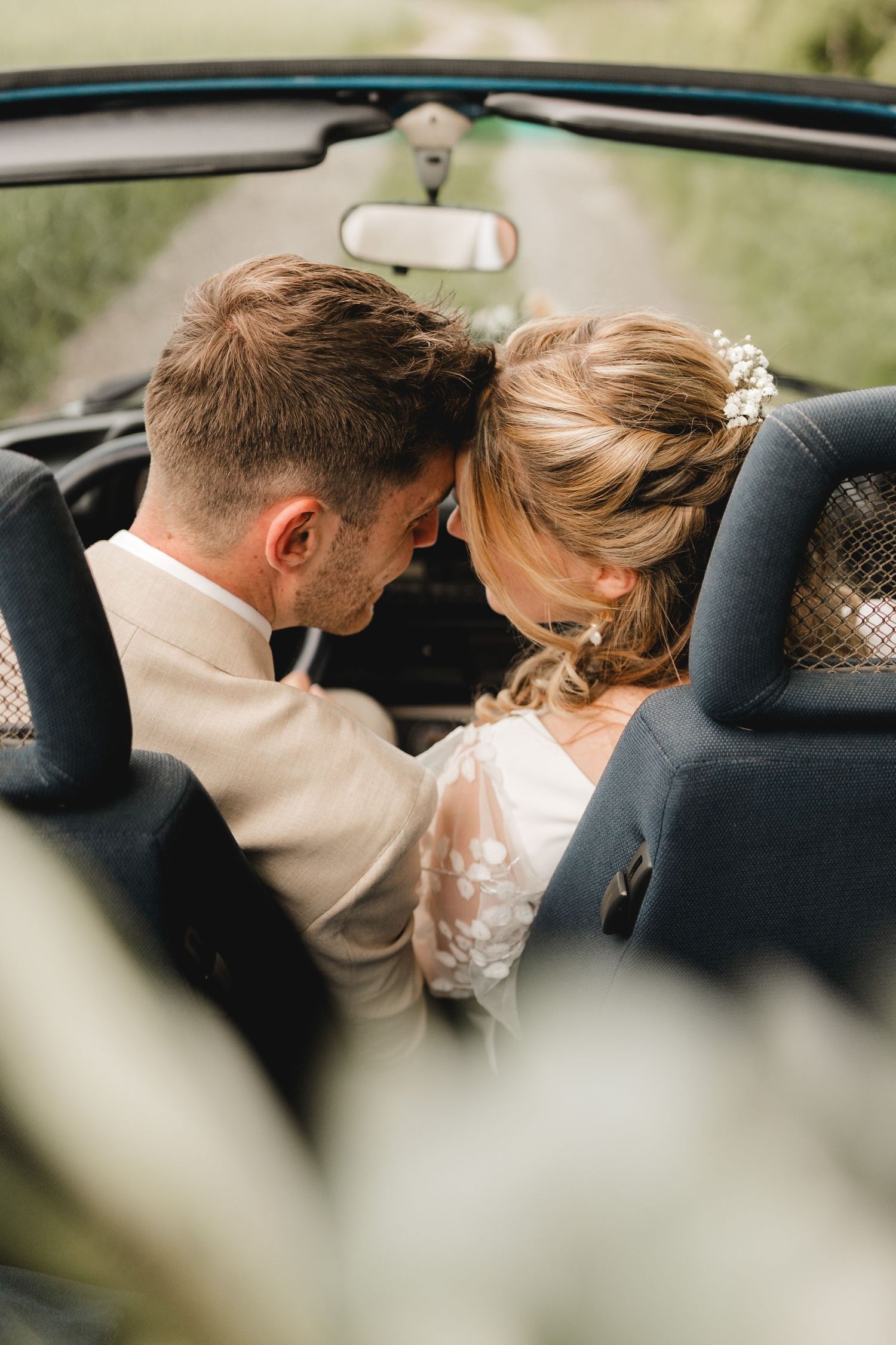 Brautpaar sitzt in einem VW-Käfer-Cabrio bei Äpfingen in der Gemeinde Maselheim - Hochzeitsfotografie Ramona Maier