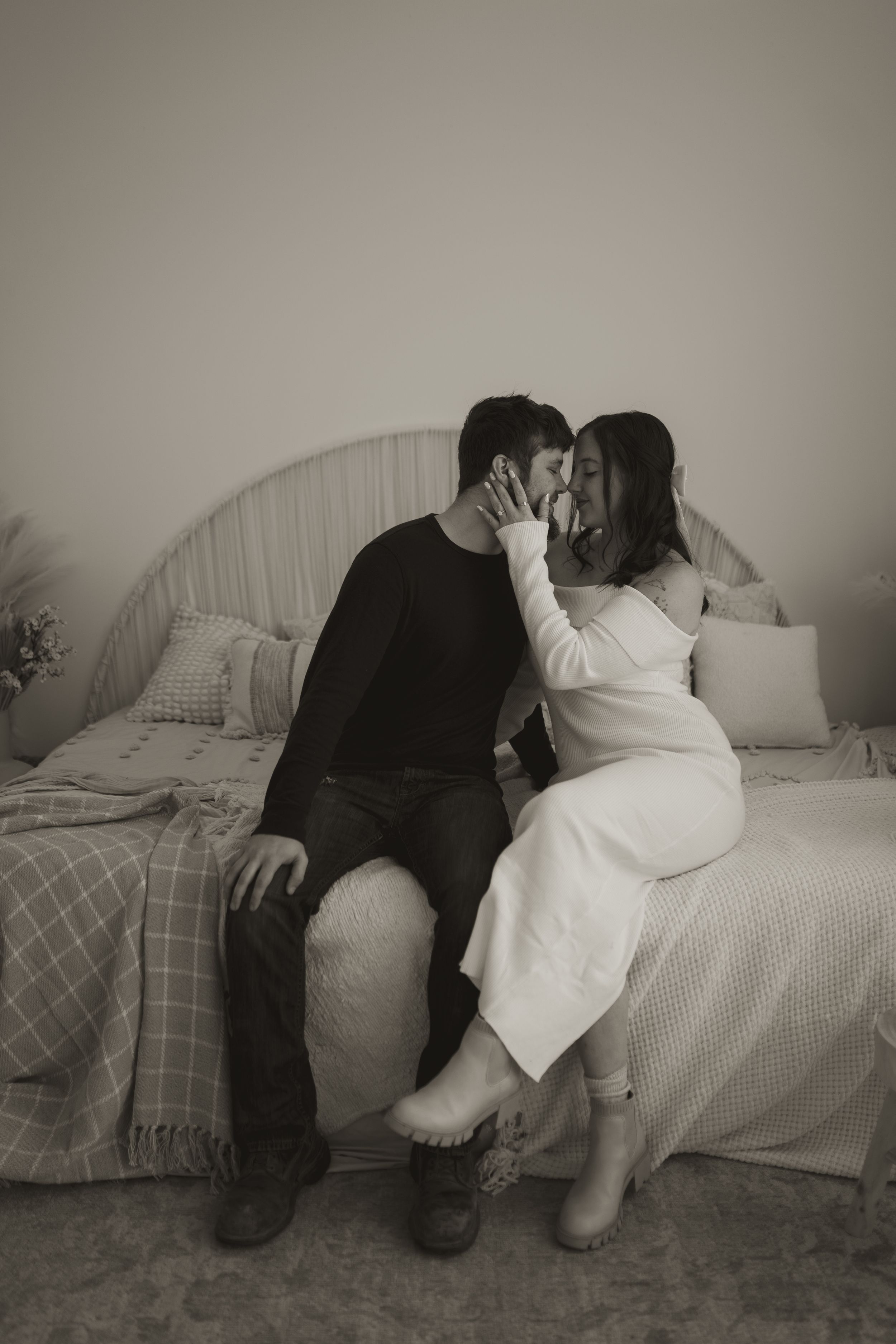 Black and white indoor portrait with couple on couch and soft lighting.