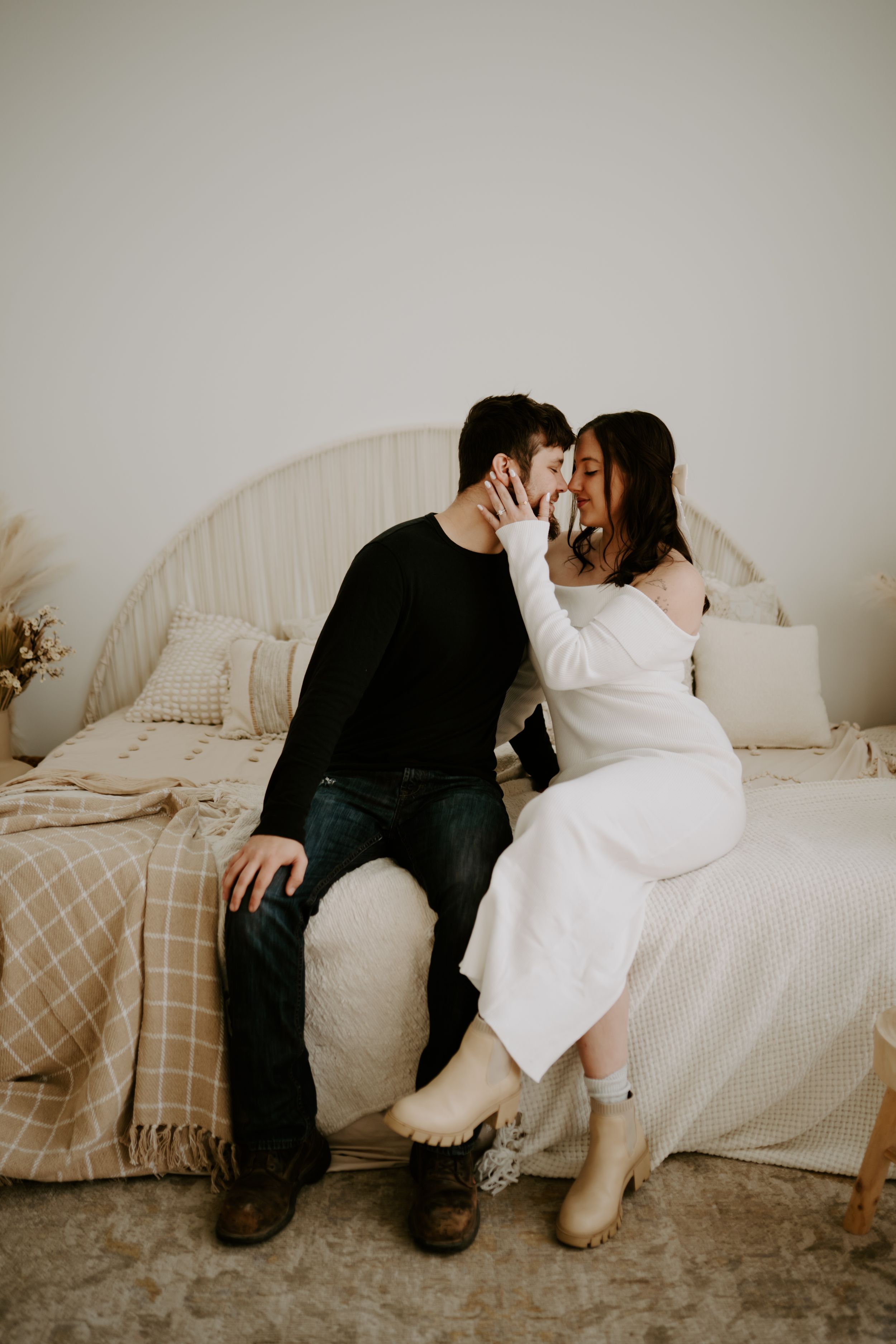 Intimate indoor portrait session on couch with neutral toned decor and blankets.