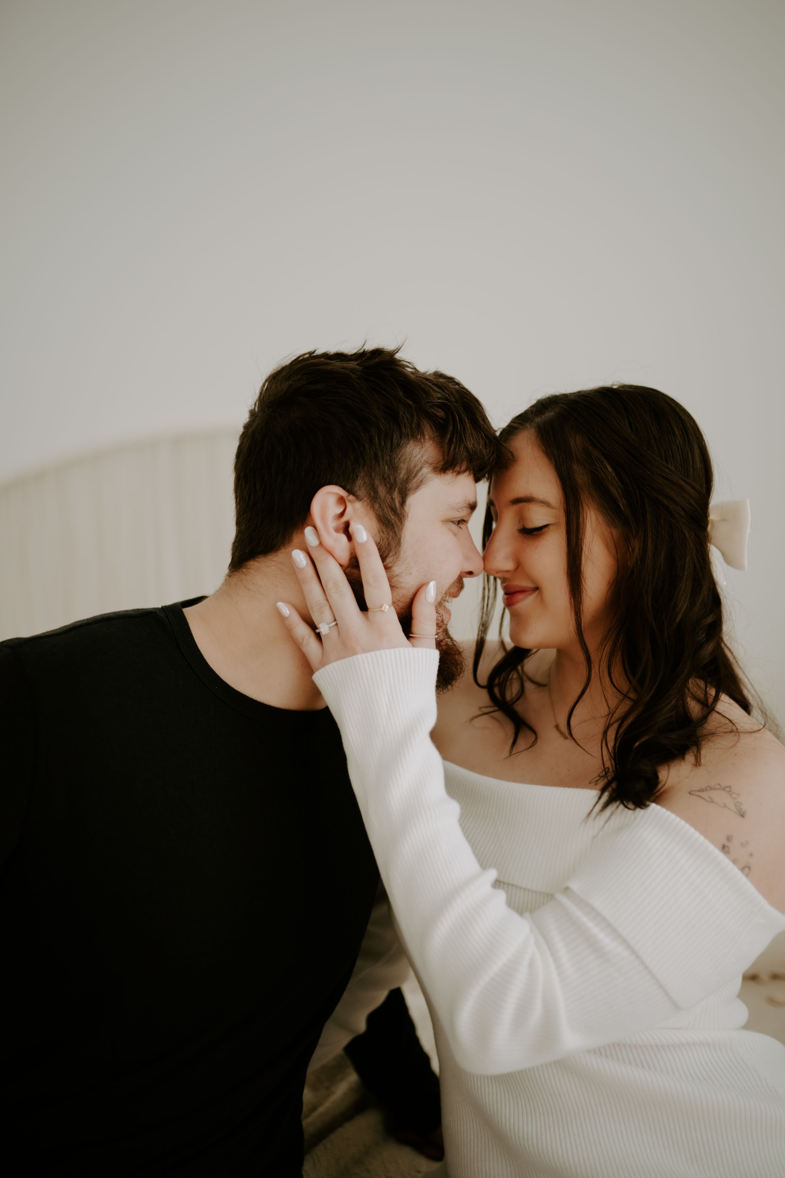 Romantic indoor photoshoot with couple in contrasting black and white outfits.