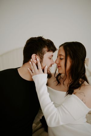 Intimate couple shares tender moments in a minimalist photo series against light background.