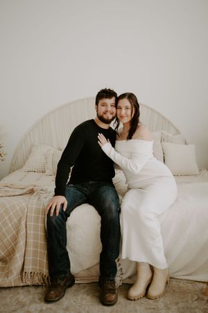 Couple sitting together on couch in casual intimate photoshoot.