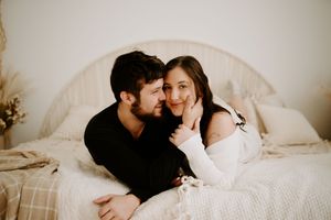 Intimate couple photoshoot with soft lighting and neutral tones.