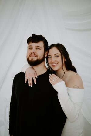 Playful couple shares laughter and embraces during minimalist photo session.