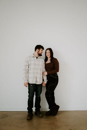 Casual couple's photography session with intimate poses against minimal background.