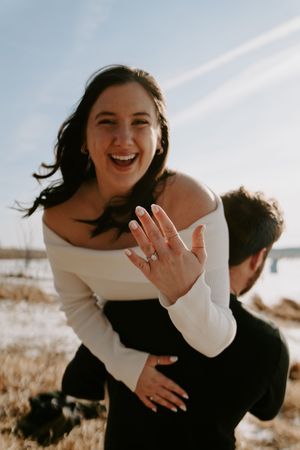 Joyful couple embraces during sunset beach photoshoot.
