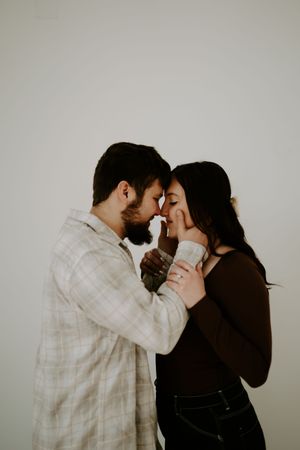 Intimate couple's portrait session against minimal grey backdrop.