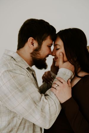 Close-up romantic moments captured against neutral background.