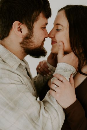 Intimate close-up portrait of couple in soft lighting.