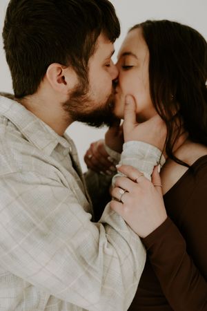 An intimate black and white portrait series showing a tender kiss between a couple.