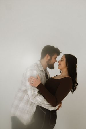 A joyful couple embraces and lifts each other in romantic black and white photos.