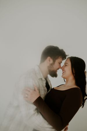 Artistic black and white photos capture a couple's romantic moment against a light background.