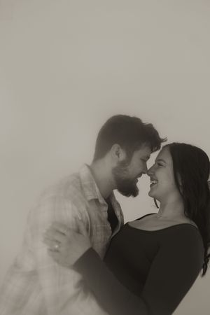 Ethereal black and white images show a couple's intimate embrace with dramatic lighting.